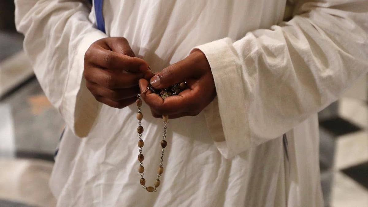 A nun of Mother Teresa's Missionaries of Charity holds a rosary during a vigil of prayer in preparation for the canonization of Mother Teresa in the St. John in Latheran Basilica at the Vatican, Friday, Sept. 2, 2016. (AP Photo/Gregorio Borgia)