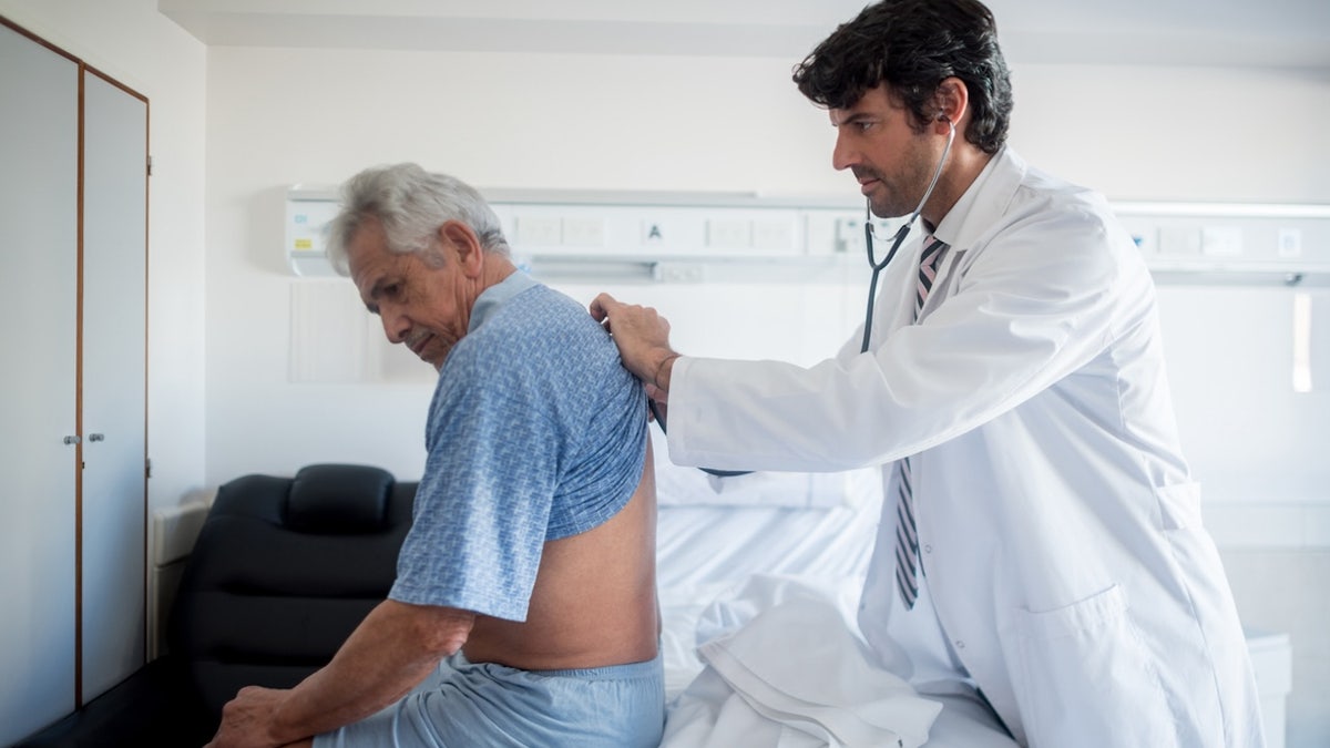 Doctor listening to man's lungs