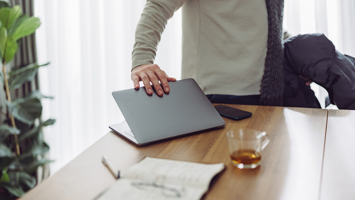 Close up photo of businessman closing his laptop 